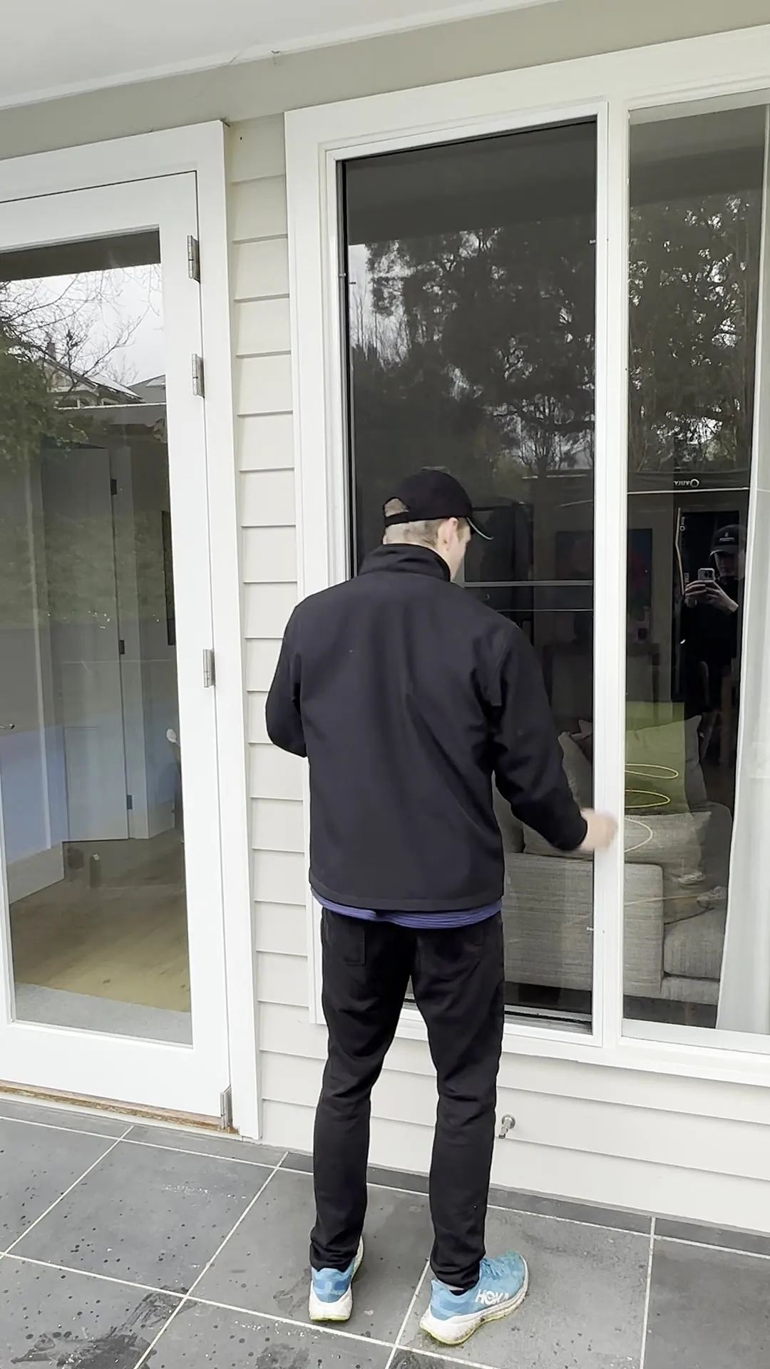 Cleaner removing a fly screen from French doors before washing it